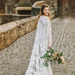 novia en boda en castillo con capa de encaje