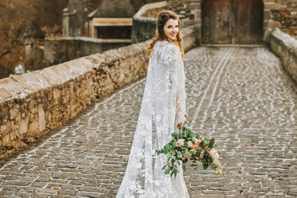 novia en boda en castillo con capa de encaje